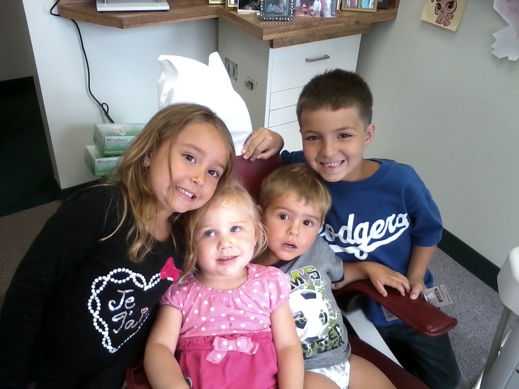four children sitting in dental chair