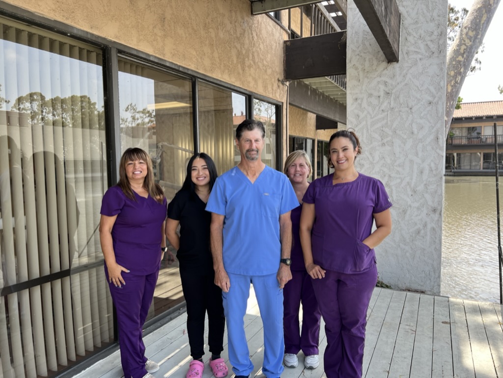 four women one man in scrubs standing in a group