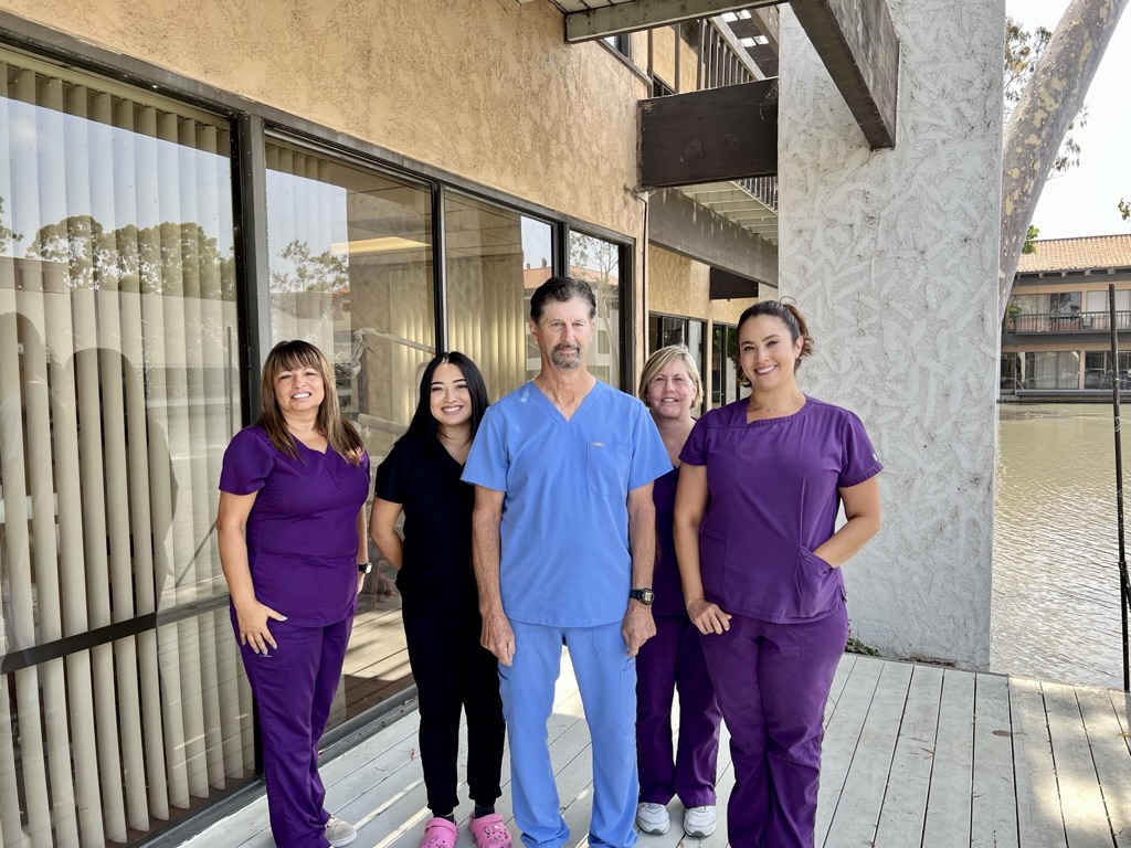 brighter photo of dental team on deck outside office